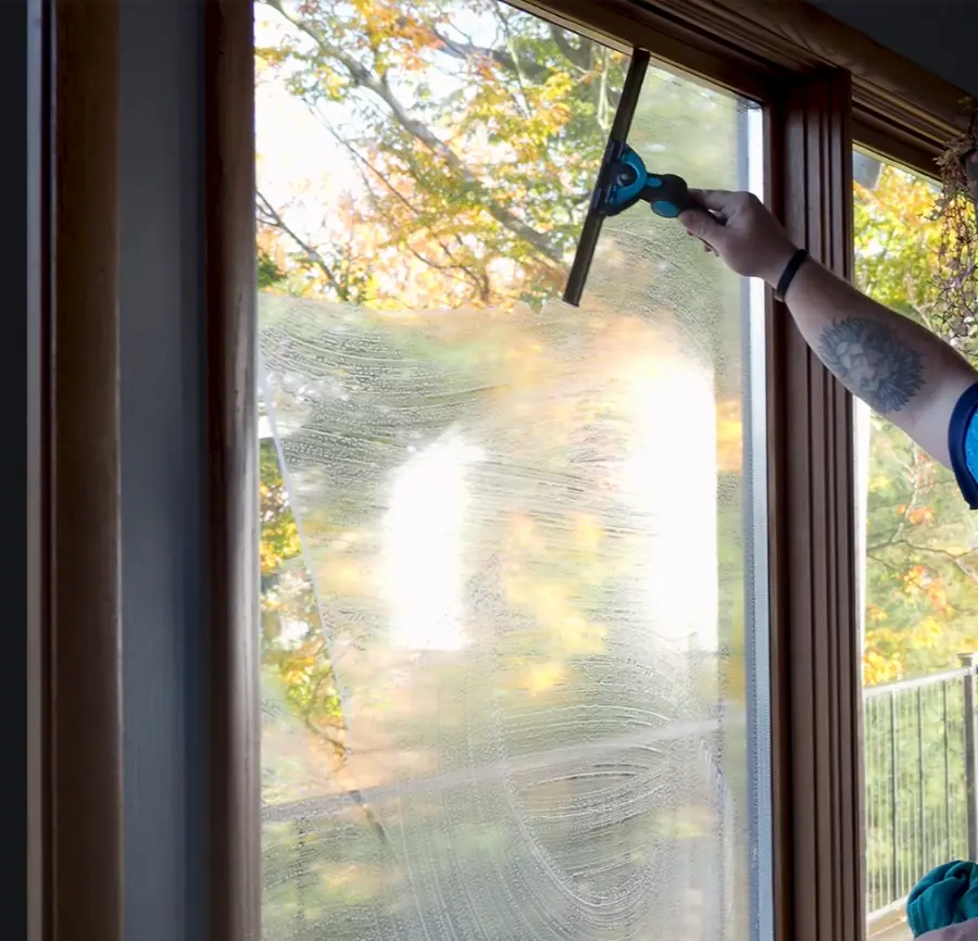 Interior window cleaning with squeegee in a San Clemente home